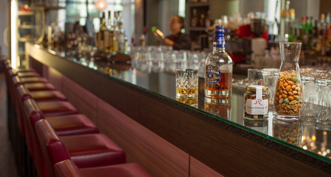 CrackersCompany-Snackglas und Karaffe an einer Hotelbar